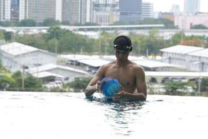 Asian men practicing swimming and preparing to play water polo and stretching and resting for water sports. photo