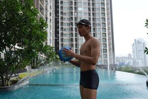Asian men practicing swimming and preparing to play water polo and stretching and resting for water sports. photo