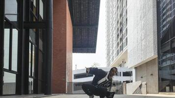 ASian man is dancing in hip hop style at outdoor space. Professional solo dancer is performing in public area. photo