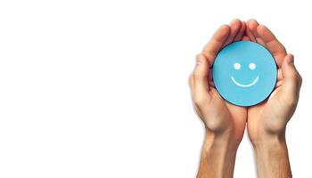 A pair of hands gently holding a blue circle with a simple, happy face drawn on it on white background photo