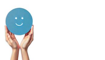 A pair of hands gently holding a blue circle with a simple, happy face drawn on it on white background photo