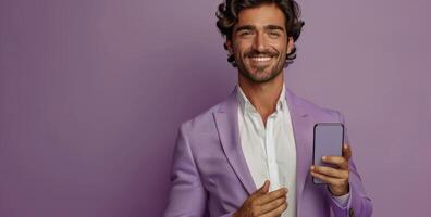 Smiling Man Holding Smartphone Against Purple Background photo