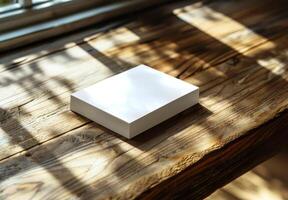 Blank White Paper Stack on Rustic Wooden Table in Sunlight photo