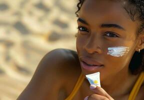 Woman Applying Sunscreen on a Beach on a Sunny Day photo