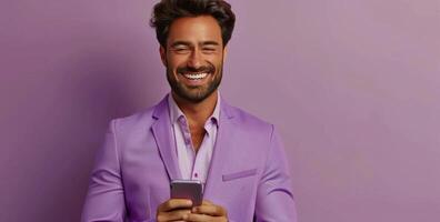 Smiling Man in Purple Suit Uses Smartphone Against Purple Background photo