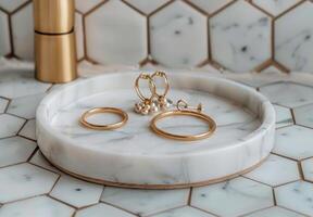 White Marble Tray With Gold Rings and Dried Eucalyptus Branch on Hexagonal Tiles photo