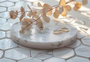 White Marble Tray With Gold Rings and Dried Eucalyptus Branch on Hexagonal Tiles photo