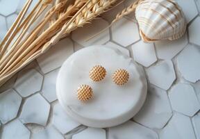 Gold Round Diamond Stud Earrings on White Marble Tray With Seashell and Wheat photo