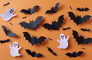 Paper Bat and Ghost Decorations on Orange Background for Halloween photo