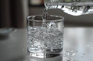 Pouring Water From A Bottle Into A Glass photo