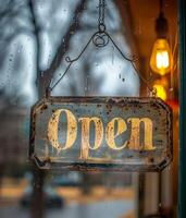 Rusty Open Sign Hanging in Rainy Window photo