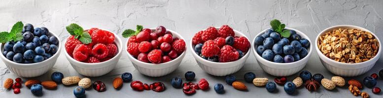 Fresh Berries and Granola in White Bowls on a Grey Surface photo