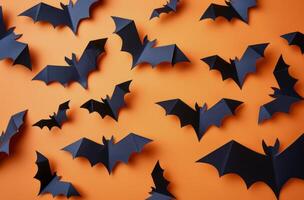 Black Paper Bats on Orange Background for Halloween Decor photo