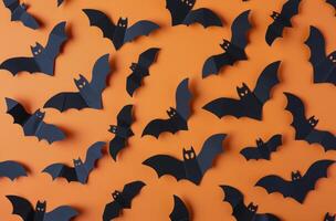 Black Paper Bats on Orange Background for Halloween Decor photo