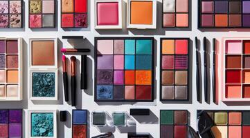 Flat Lay of Assorted Makeup Products and Brushes on White Background photo