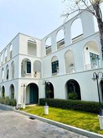 Modern white townhouses, large with 3 floors, front with a lamp post and a small garden photo