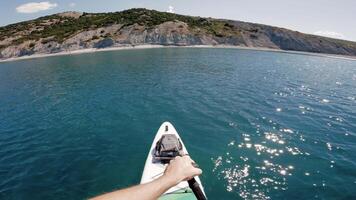 Men rowing on stand paddle board on quiet sea. First person view of stand paddle boarding in summer. video
