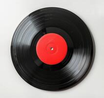 A Worn Vinyl Record With A Red Label On A White Background photo