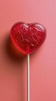 Pink Heart Shaped Lollipop on a Pink Background photo