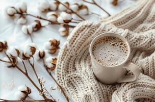 White Cotton Branch and Beige Knit Blanket With Cup of Coffee on White Background photo