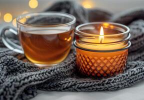 Lit Candle and Glass of Tea on a White Shag Rug With a Knit Blanket photo