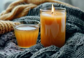Lit Candle and Glass of Tea on a White Shag Rug With a Knit Blanket photo