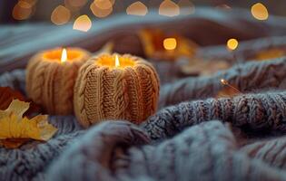 Cozy Knitted Candles on a Grey Blanket With Autumn Leaves photo