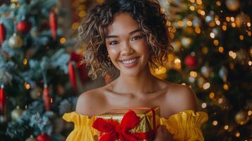 Woman Holding Wrapped Present in Front of Christmas Tree photo