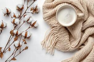 White Cotton Branch and Beige Knit Blanket With Cup of Coffee on White Background photo