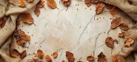 Dried Autumn Leaves and Burlap Fabric on White Background photo