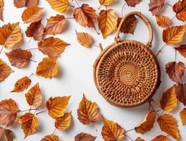 Wicker Bag With Autumn Leaves on a White Background photo