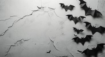 Black Paper Bats Decorated on a Cracked White Wall photo