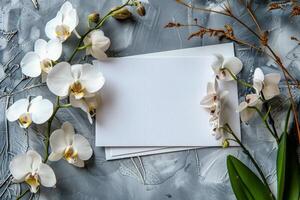 White Orchid Flowers and Blank Card on Grey Background photo
