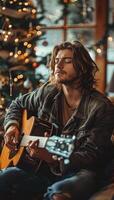 Man Playing Acoustic Guitar by Christmas Tree With Warm Lights photo