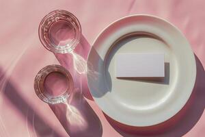 White Card Mockup With Glass of Water on Pink Background With Sunlight photo