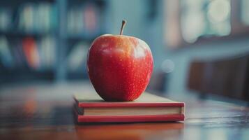 A Red Apple Resting on a Textbook in a Classroom photo