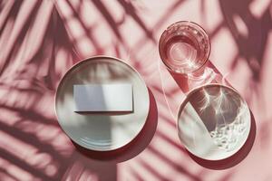 White Card Mockup With Glass of Water on Pink Background With Sunlight photo
