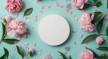 White Plate Surrounded by Pink Peonies and Green Leaves on a Pink Background photo