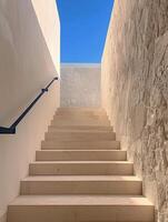 White Stone Staircase Leading Up to a Blue Sky View in a Modern Building photo