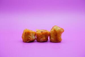 3 fried bananas isolated on purple background photo