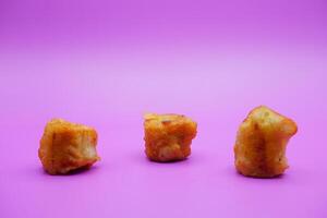 3 fried bananas isolated on purple background photo
