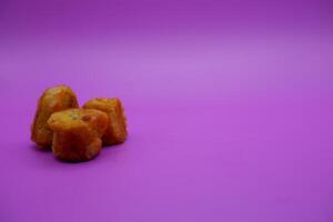 3 fried bananas isolated on purple background photo