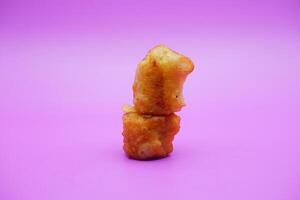 fried banana isolated on purple background. mini fried bananas photo