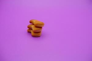 three biscuits shaped like fish isolated on a purple background photo