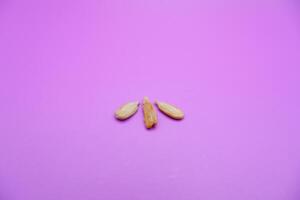 peeled sunflower seeds snack isolated on a purple background photo