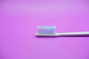 White toothbrush isolated on purple background photo