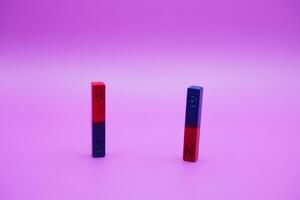 two bar magnets isolated on a purple background photo