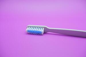 White toothbrush isolated on purple background photo