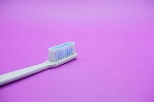 White toothbrush isolated on purple background photo