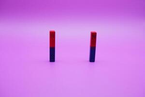 two bar magnets isolated on a purple background photo